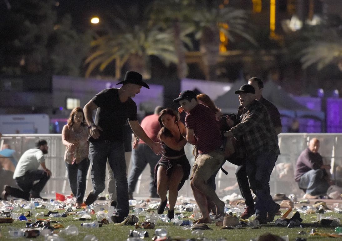 People assist a woman injured by a spray of bullets in Las Vegas.
