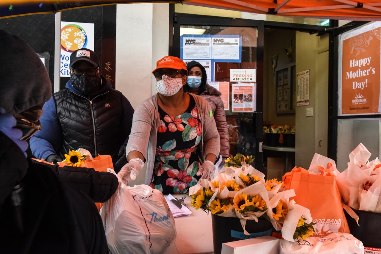 Los trabajadores de la despensa de alimentos entregan artículos a los clientes del Community Kitchen y Food Pantry en el vecindario de Harlem en la ciudad de Nueva York.
<br>El Banco de Alimentos de la Ciudad de Nueva York junto con esta despensa de alimentos distribuyó productos para bebés, alimentos y flores en honor del Día de la Madre el viernes 8 de mayo.
<br>