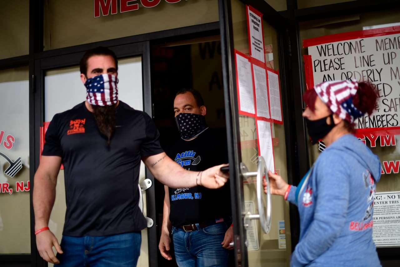 Los empleados de gimnasio Atilis salen para saludar a los clientes que se reunieron afuera del local el 20 de mayo como medida de apoyo.