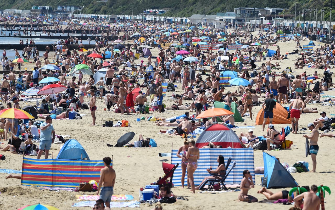 Una multitud de bañistas en la playa de Bournemouth, Reino Unido, el 25 de mayo. El gobierno británico comenzó a aliviar las restricciones y cambió el lema "quedarse en casa" por "estar alerta".
<br>