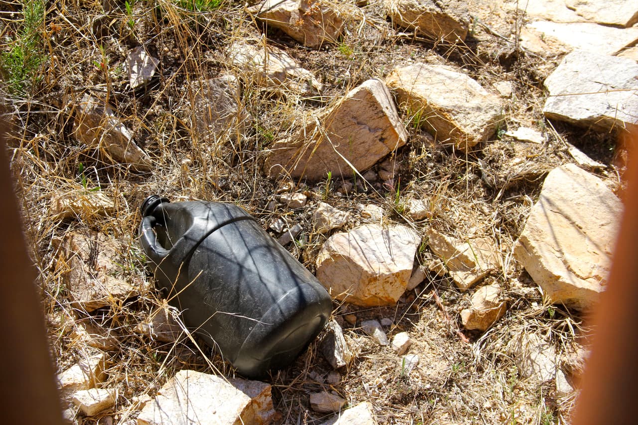 Foley muestra uno de los cientos de potes negros que son dejados a lo largo del muro fronterizo.