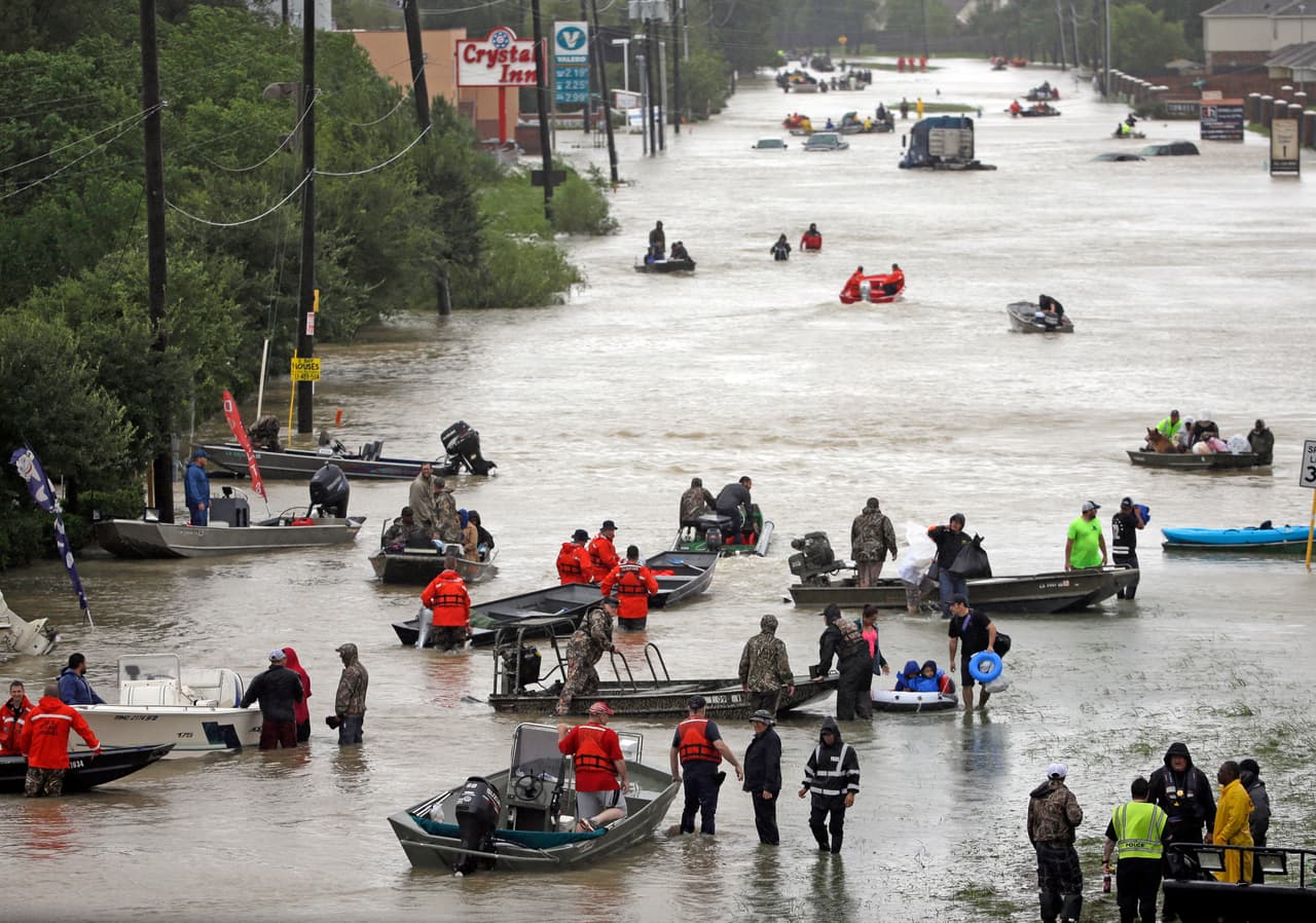 Una calle inundada es navegada por decenas de botes, al norte de Houston.