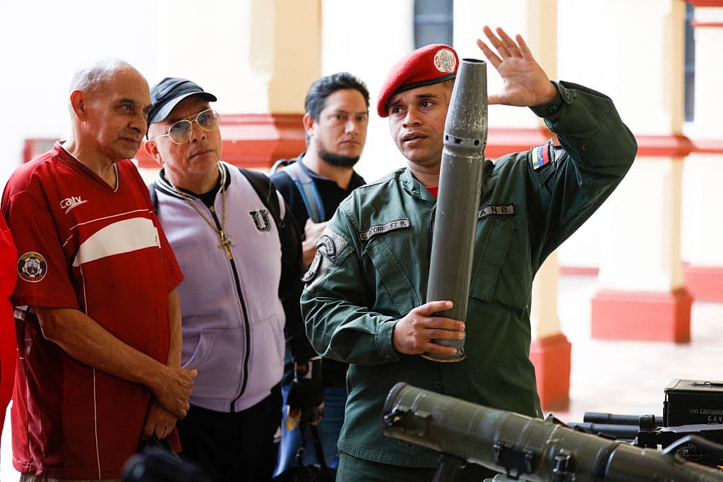 Un miembro de la guardia presidencial muestra armas durante una ceremonia de inducción para las personas que se inscribieron en la campaña de alistamiento de la Milicia Nacional Bolivariana convocada por el gobierno del presidente Nicolás Maduro en el museo militar 4F en Caracas, el 23 de agosto de 2025. Miles de personas se alistaron el sábado en las fuerzas militares de Venezuela para engrosar las filas de cara a una posible invasión estadounidense.