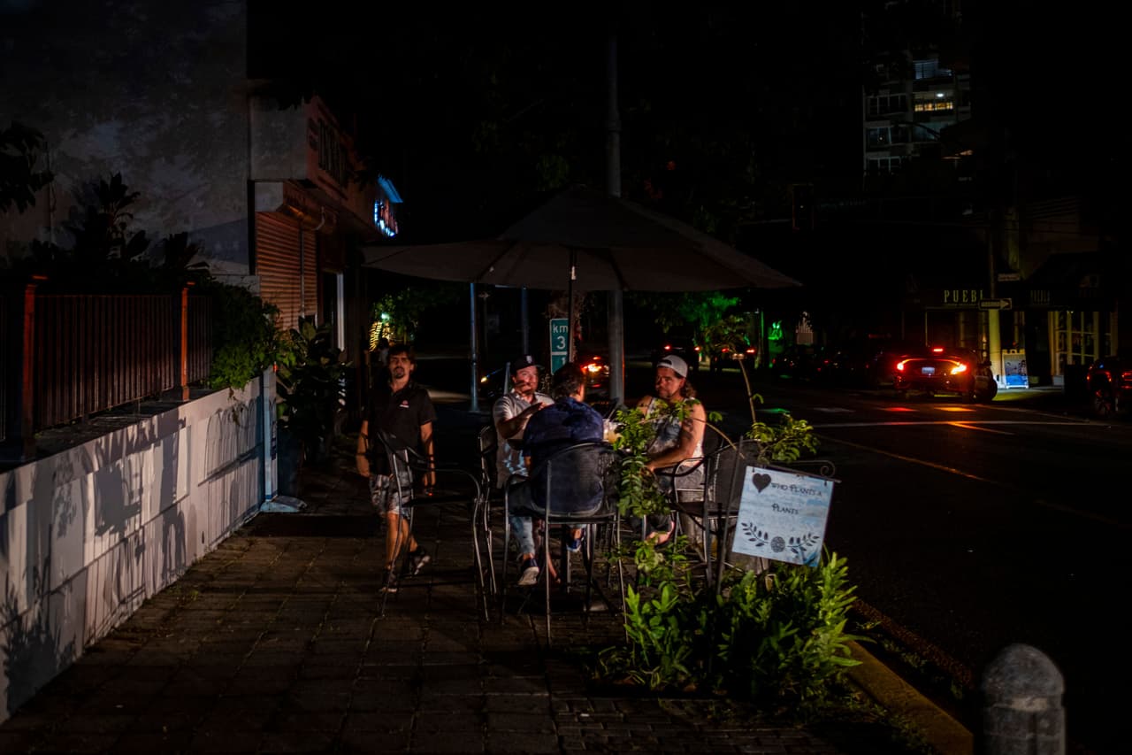 Aquí se ven personas afuera de un restaurante en una calle oscura generalmente concurrida en San Juan, Puerto Rico.