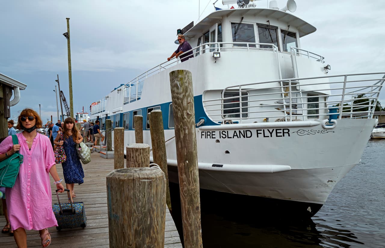 Varias personas desembarcan de un ferry en Bay Shore, Nueva York, que procedía de Fire Island uno de los sitios en los que se emitió orden de evacuación el sábado 21 de agosto antes del impacto de
<a href="https://www.univision.com/local/nueva-york-wxtv/los-esfuerzos-de-autoridades-en-nueva-york-para-evitar-posibles-inundaciones-debido-a-la-tormenta-tropical-henri-video">Henri</a>.