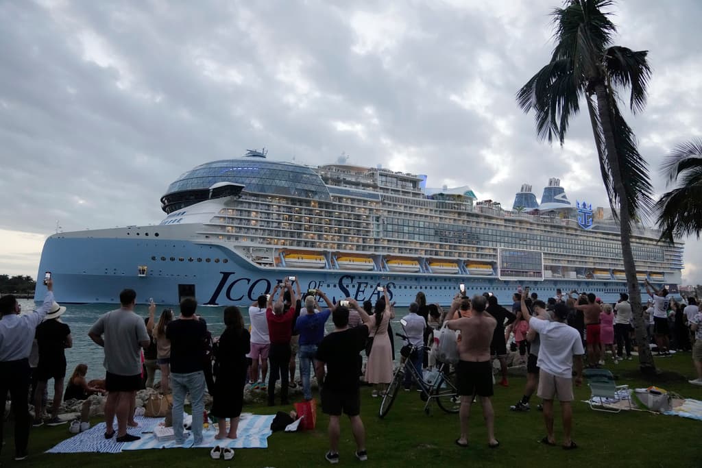 La gente toma fotos y videos desde South Pointe Park, mientras el Icon of the Seas, el crucero más grande del mundo, zarpa de PortMiami en su primer crucero público.