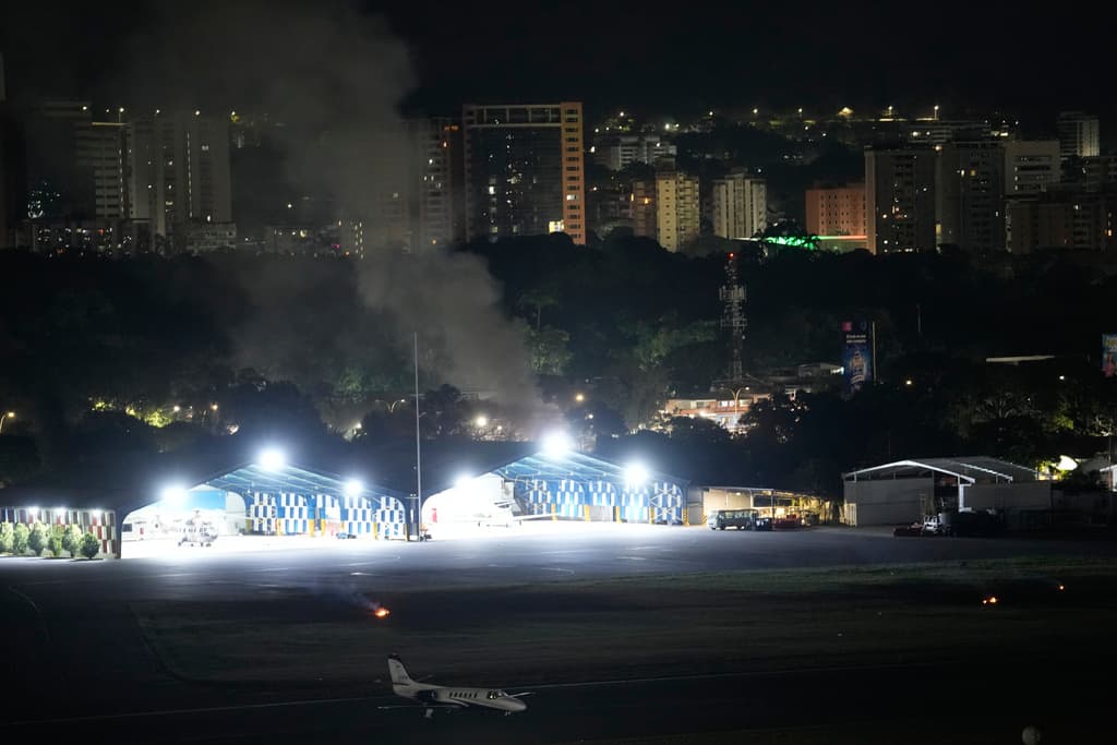 En la imagen, humo en el aeropuerto de La Carlota tras varias explosiones y aviones volando a baja altura en Caracas, Venezuela, el 3 de enero de 2026. (AP Foto/Matías Delacroix)