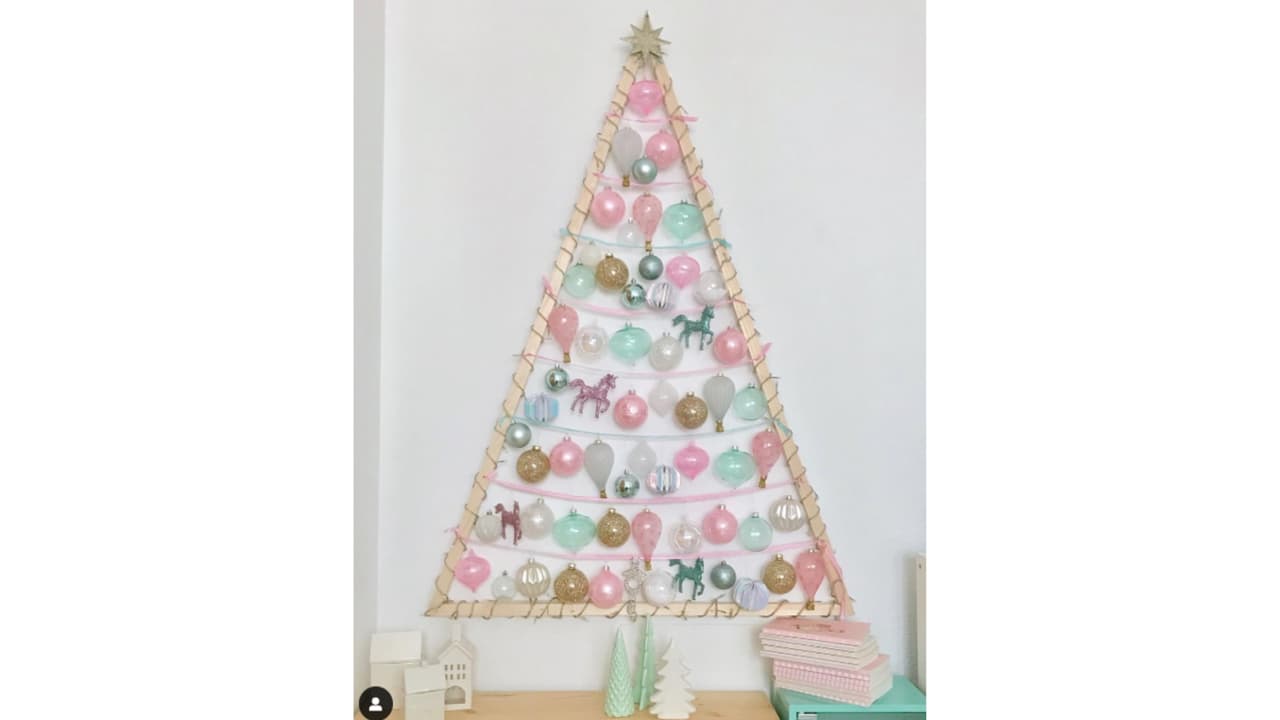 Árbol de Navidad en la pared con adornos en colores pastel