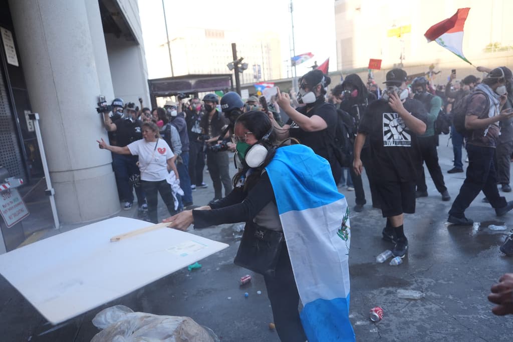 Manifestantes se enfrentan a la policía federal que dispara gases lacrimógenos en el Centro de Detención Metropolitano en el centro de Los Ángeles.