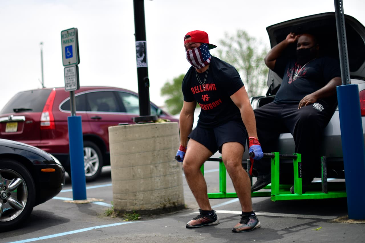 Un fisicoculturista levanta un automóvil fuera del gimnasio Atilis durante una protesta el 20 de mayo. Ese mismo día, el Departamento de Salud de Nueva Jersey emitió una orden de cierre de emergencia para el gimnasio.
<br>