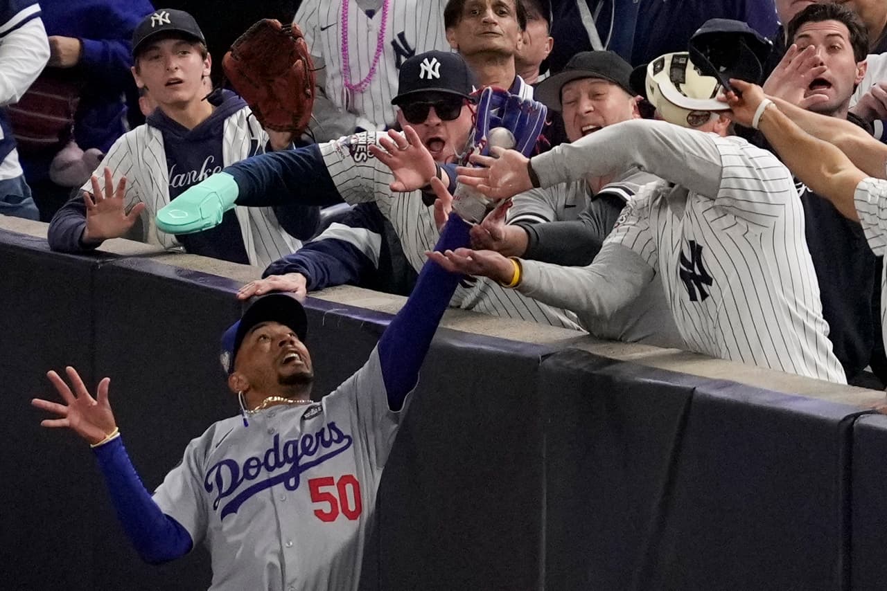Aficionados interfieren con una pelota atrapada por el jardinero derecho de los Dodgers de Los Ángeles, Mookie Betts, durante la primera entrada del cuarto juego de la Serie Mundial de béisbol contra los Yankees de Nueva York, el martes 29 de octubre de 2024, en Nueva York.
<a href="https://www.youtube.com/watch?v=y1VboBz_MrI" target="_blank">Los Dodgers ganaron la octava Serie Mundial de su historia frente a sus rivales neoyorquinos. </a>