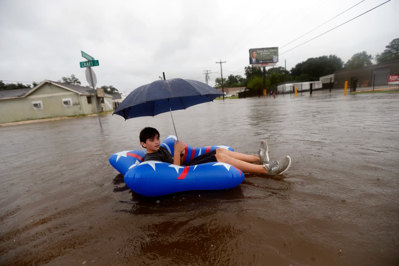 Julius Verret, de 14 años, flota en las inundaciones de la calle en Lake Charles, Texas.