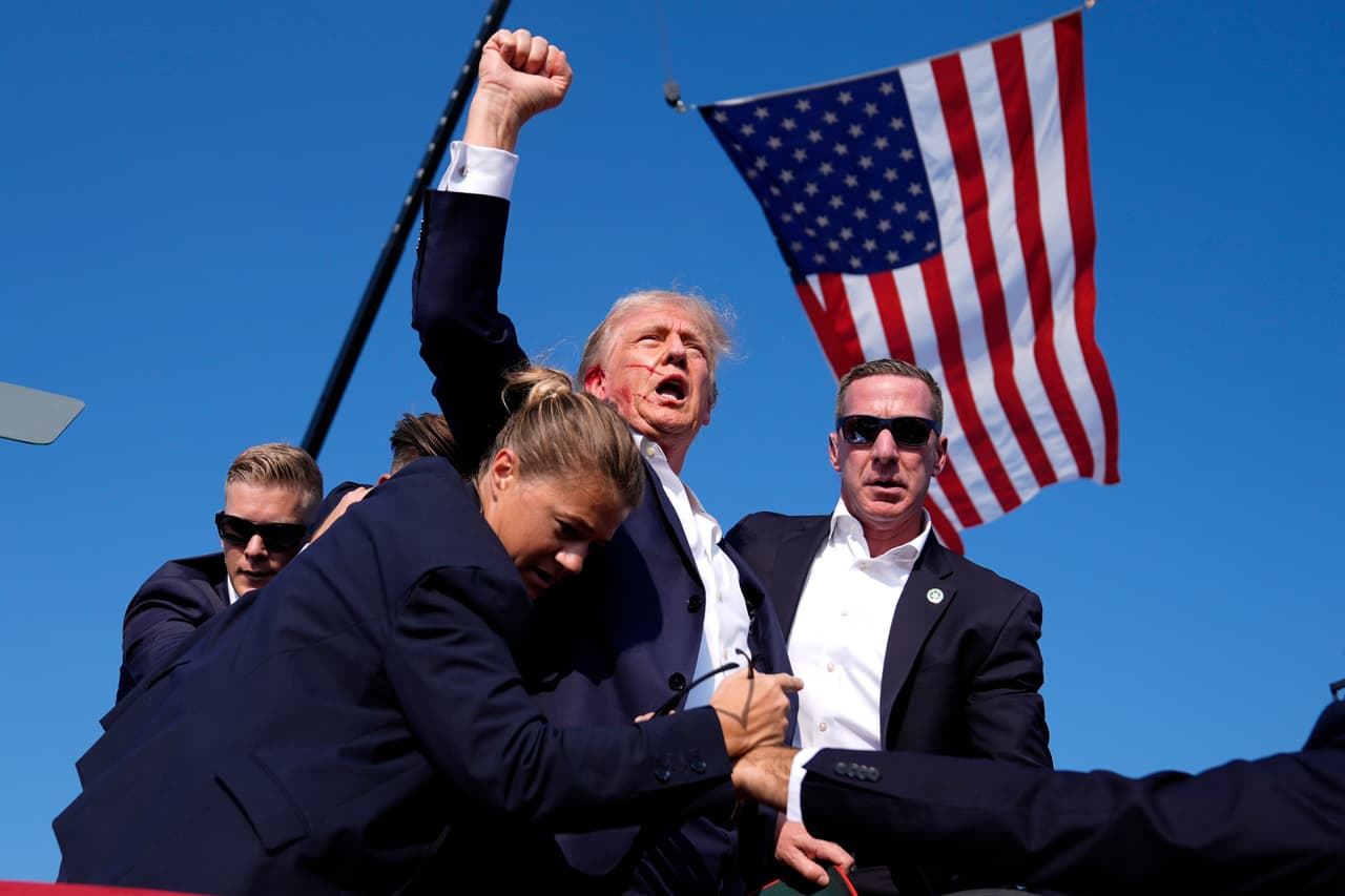 Trump levanta el puño y grita "pelea" mientras lo ayudan a bajar del escenario en un evento de campaña en Butler, Pensilvania, el sábado 13 de julio de 2024. Segundos antes, un joven disparó contra Trump, con el objetivo de matarlo. Una bala terminó rozándole la oreja, hiriéndolo levemente.
<a href="https://www.univision.com/noticias/elecciones-en-estados-unidos-2024/servicio-secreto-necesita-una-sacudida-luego-del-intento-de-asesinato-de-trump">El ataque mató a un asistente del mitin, Corey Comperatore, de 50 años.</a> Esta foto se volvió icónica para los seguidores del republicano.