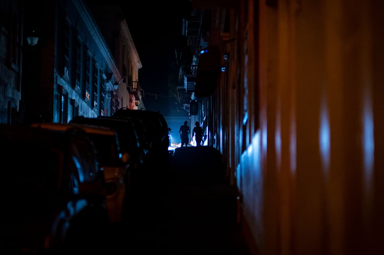 Se ve a personas caminando en una calle que quedó a oscuras por un corte de energía en el Viejo San Juan, Puerto Rico.