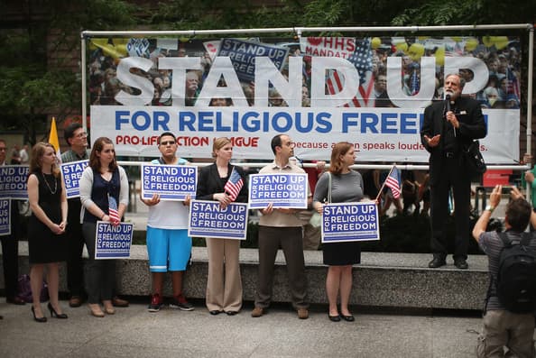 Fr. Thomas Loya (R) speaks at a rally in support of religious freedom after the Supreme Court's decision in the Hobby Lobby, contraception coverage requirement case on June 30, 2014 in Chicago, Illinois.