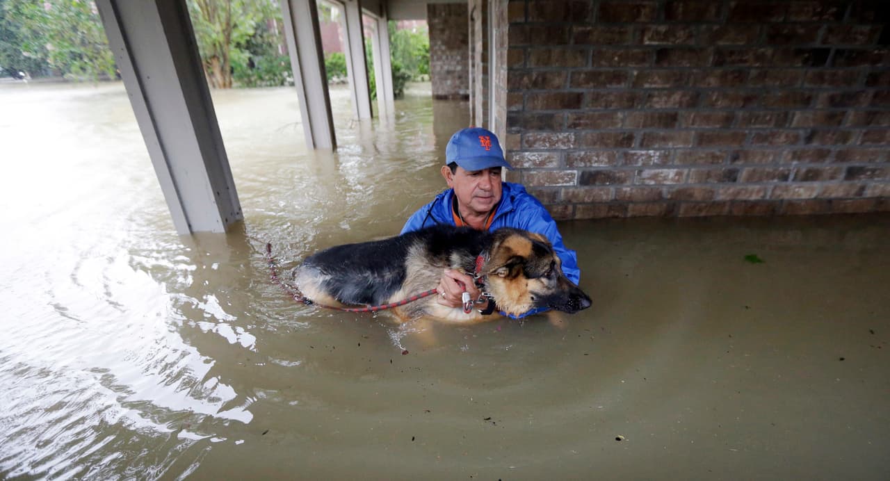 Joe García rescata a su perra Heidi de las aguas que inundan su hogar en Spring, Texas.