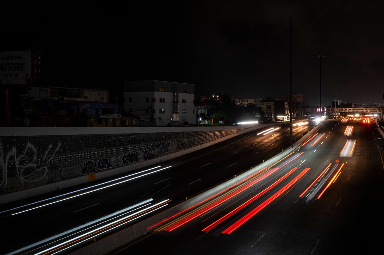 Los automóviles circulan en una carretera oscura y transitada mientras la ciudad queda a oscuras por el corte de energía, en el Viejo San Juan, Puerto Rico.