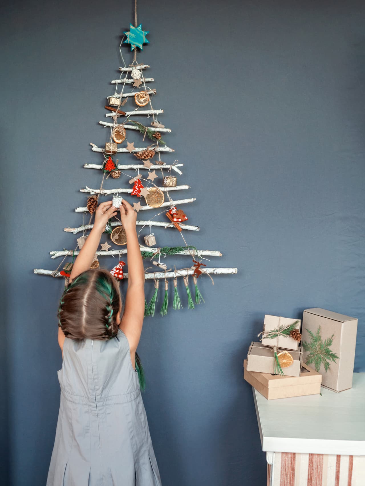 Niña decorando un árbol de Navidad en la pared