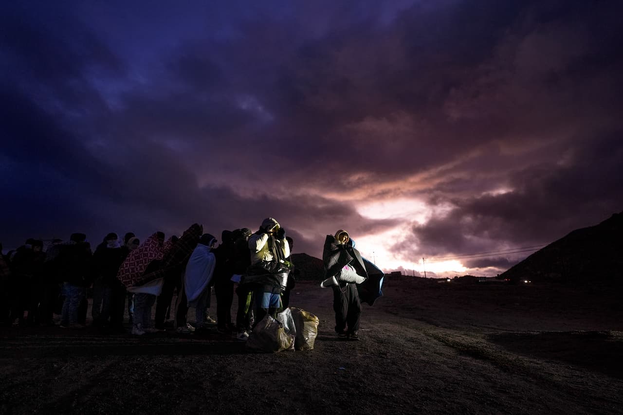 Migrantes solicitantes de asilo envueltos en mantas hacen fila en un campamento improvisado tras cruzar la frontera con México, el viernes 2 de febrero de 2024, cerca de Jacumba Hot Springs, California. La imagen ilustra las condiciones difíciles que enfrentan quienes aspiran a llegar a EEUU. Este año de elecciones, otra vez, los inmigrantes han sido el centro de la campaña presidencial: finalmente,
<a href="https://www.univision.com/noticias/elecciones-en-estados-unidos-2024/trump-redadas-masivas-batalla-milicias-margen-espera">Trump ganó un segundo mandato, con promesas de deportaciones masivas. </a>