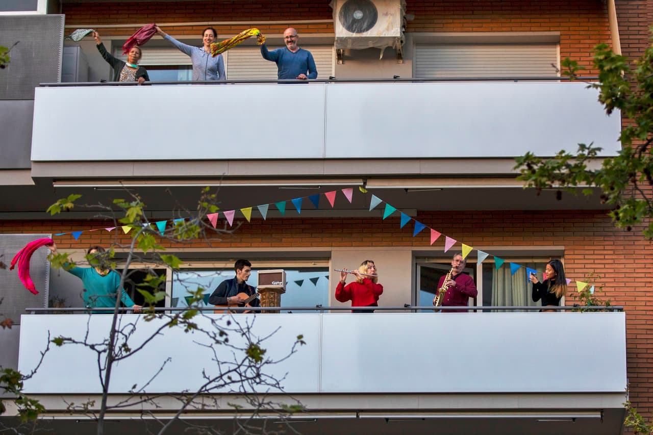 <b>El reencuentro entre vecinos</b>. Algunas ciudades tuvieron períodos de confinamiento largos y los balcones y ventanas se transformaron en el centro social. Conciertos, conversaciones, fiestas y manifestaciones se realizaron sin salir de casa. En la fotografía un cuarteto toca en un balcón y los vecinos
<a href="https://www.univision.com/noticias/salud/fotos-en-la-era-del-coronavirus-y-la-cuarentena-los-balcones-son-el-centro-de-la-vida-social-fotos"><u>disfrutan y bailan la presentación</u></a>. Barcelona, España, 5 de abril.