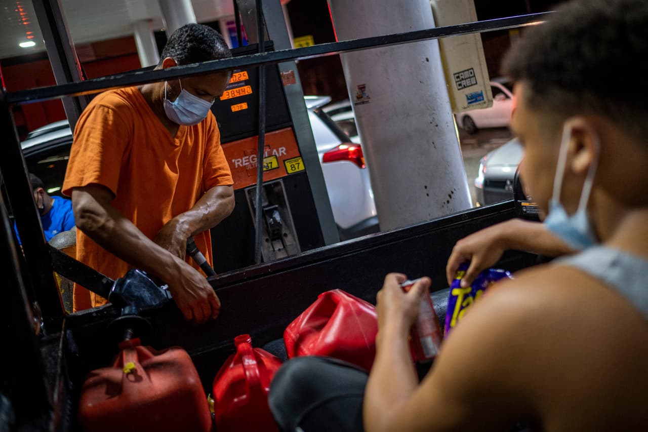 Un hombre llena contenedores con gasolina tras los apagones. Mucha gente asturó las estaciones para abastecer sus generadores de electricidad.