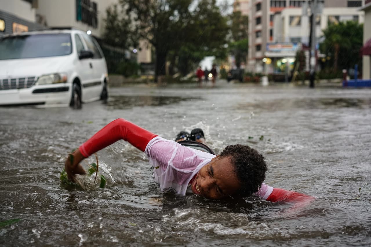 A child plays in a flooded street in San Juan.