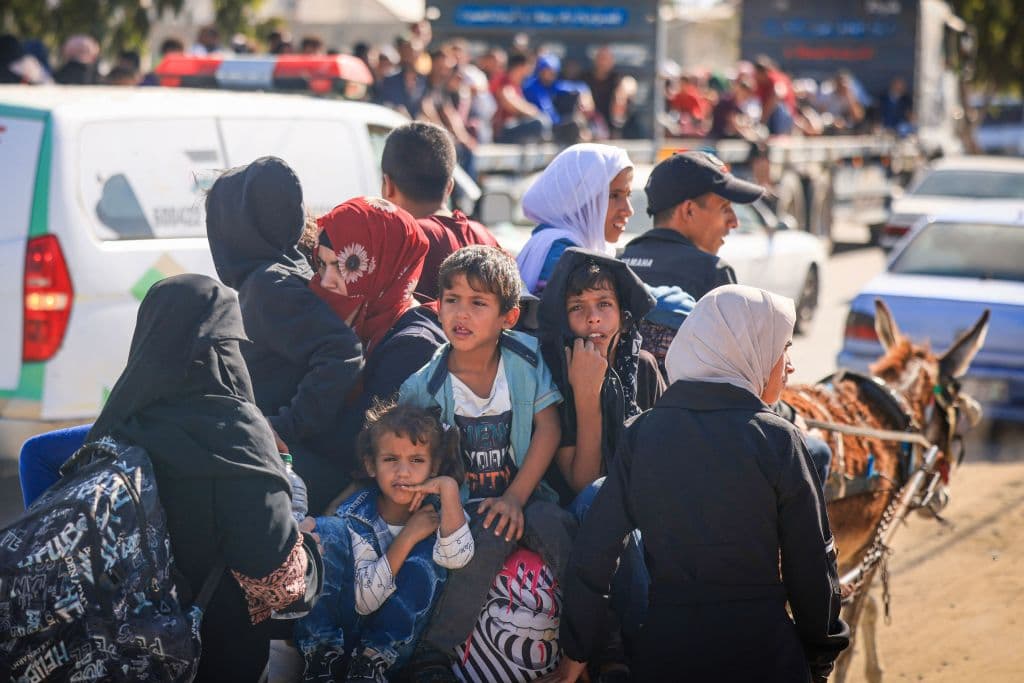 Palestinos con sus pertenencias abandonan la ciudad de Gaza a bordo de una carreta jalada por un burro.