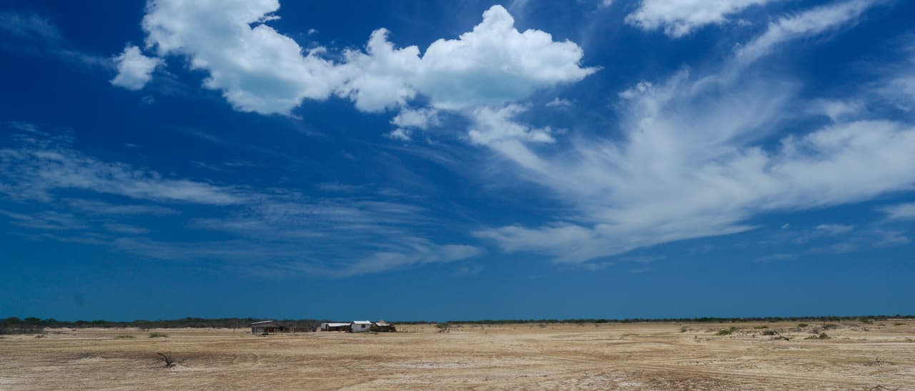 A Wayuú ranchería sits on the horizon of La Guajira's expansive desert.