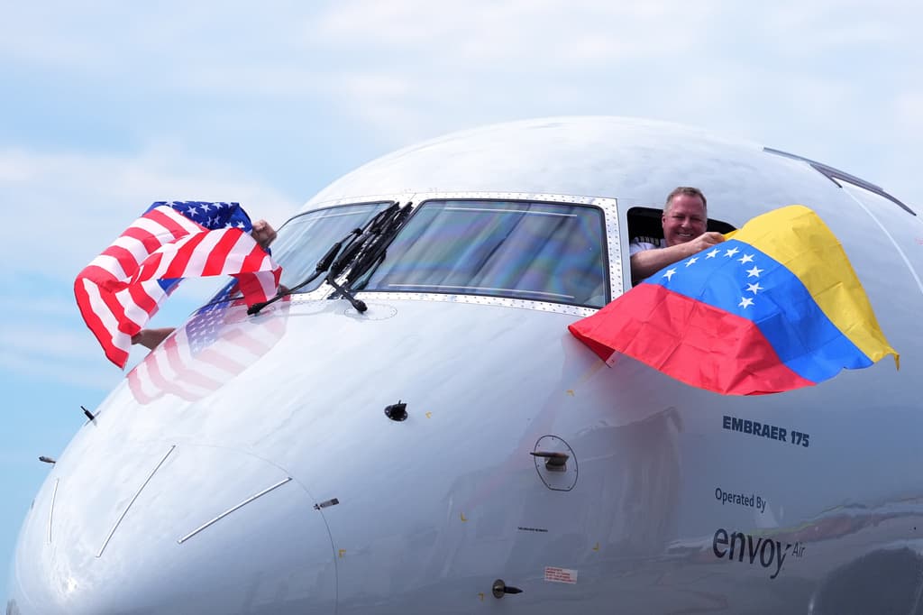 El capitán Ric Wilson ondea una bandera venezolana y el primer oficial ondea la bandera estadounidense mientras se preparan para despegar con rumbo al aeropuerto internacional Simón Bolívar de Maiquetía.