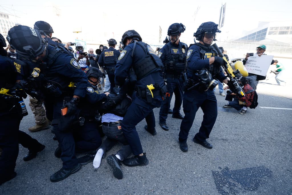<b>Un manifestante</b> en el justo momento en que quedó
<b>sometido a la obediencia</b>, el sábado, 6 de junio, en las inmediaciones del
<b> Centro de Detención Metropolitano federal</b>, en Los Ángeles.
<br>
<br>No fue el único detenido durante un evento en el que más de 150 personas, entre
<b>activistas, familiares y amigos,</b> conmemoraron
<b><a href="https://www.univision.com/noticias/inmigracion/graves-enfrentamientos-agentes-manifestantes-los-angeles-redadas-ice?sfd" target="_blank">el primer año de las redadas masivas de inmigración en la ciudad</a></b>.