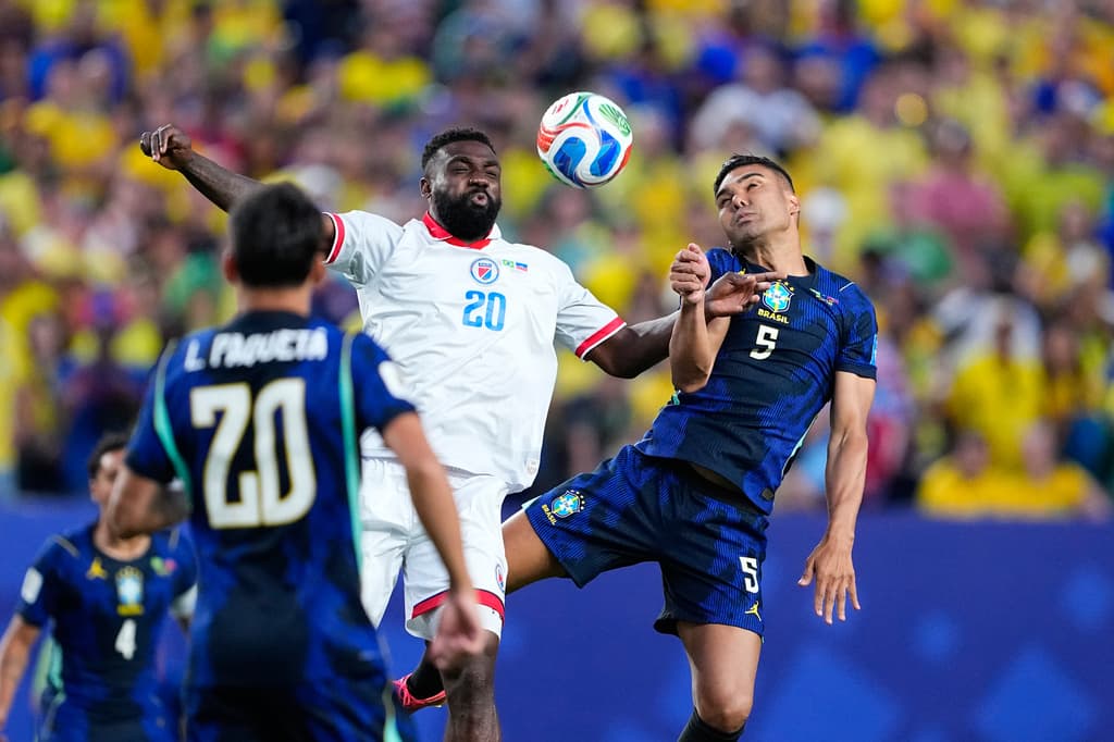 Casemiro de Brasil choca fuerte con Frantzdy Pierrot de Haití peleando el balón en una aguerrida jugada durante el partido del Grupo C.