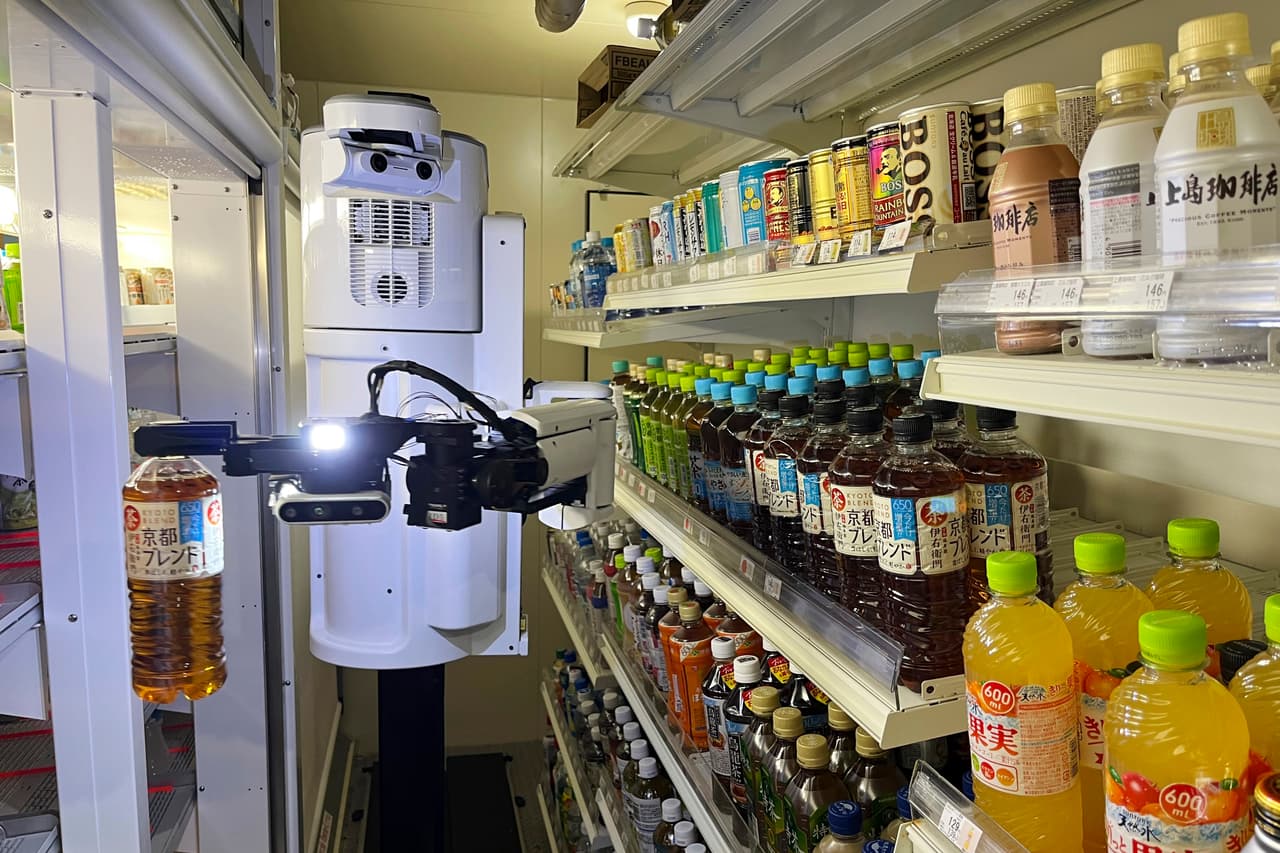 <b>13.- Tendero.</b> El robot TX SCARA trabaja almacenando bebidas en la sección refrigerada de una tienda de conveniencia FamilyMart en Tokio, el viernes 26 de agosto de 2022. El robot puede reabastecer los estantes con hasta 1,000 botellas y latas por día.