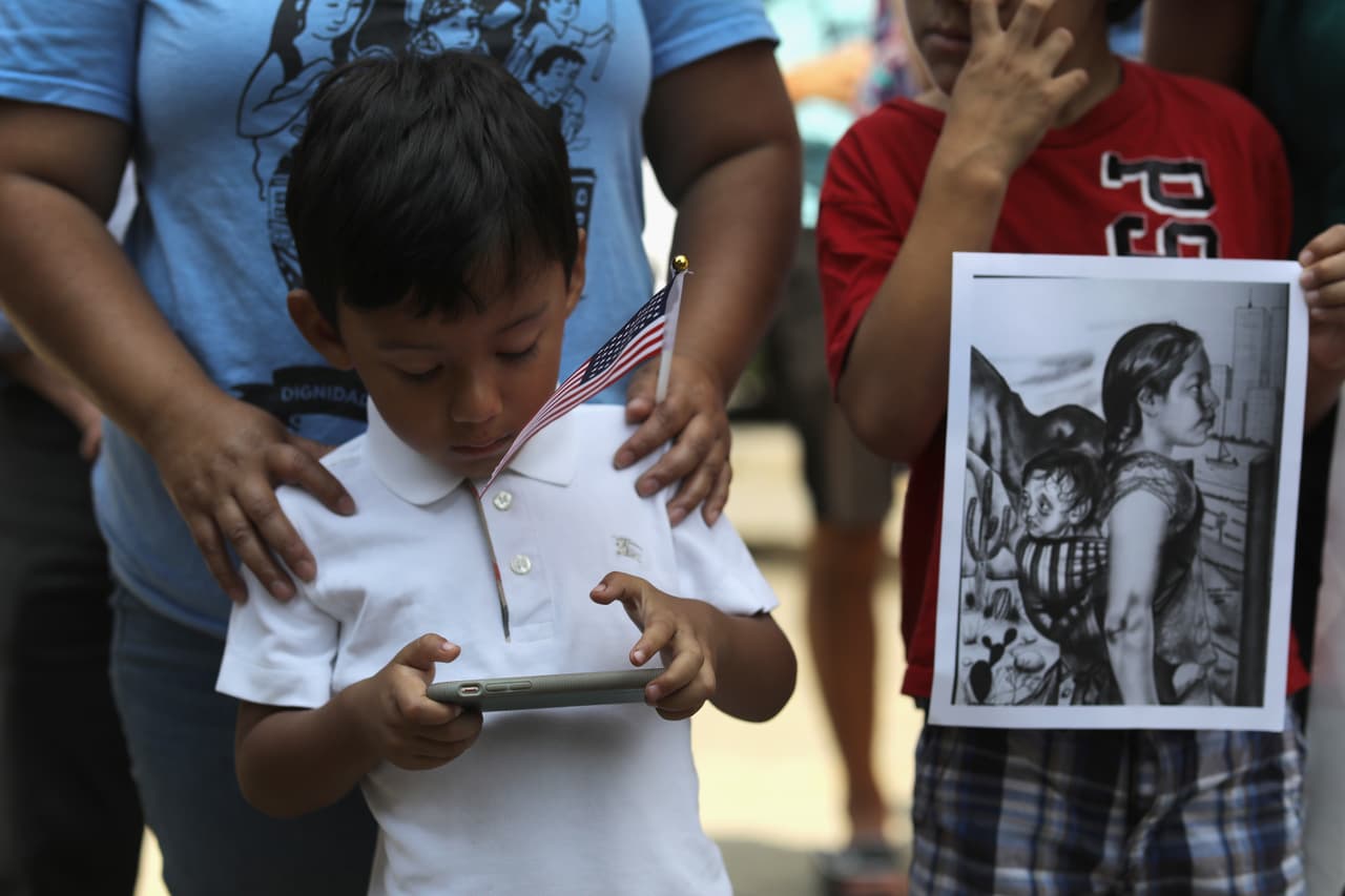 BRIDGEPORT, CT - JULY 11: A boy plays on his mobile phone as protesters rally against the separation of immigrant families in front of a U.S. federal court on July 11, 2018 in Bridgeport, Connecticut. The rally was in support of two Central American children separated from their parents as a result of the Trump administration's "zero tolerance" policy on undocumented immigration at the southern border. The two children, who are reportedly being held in a facility in Groton, CT were to appear at a court hearing ahead of possible reunification with their parents. (Photo by John Moore/Getty Images)