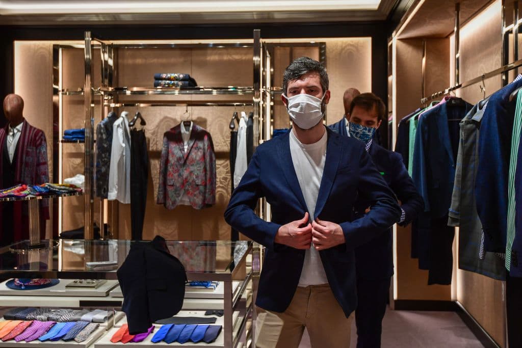 Un cliente en la tienda de ropa Etro fashion en Milán, se prueba una chaqueta.