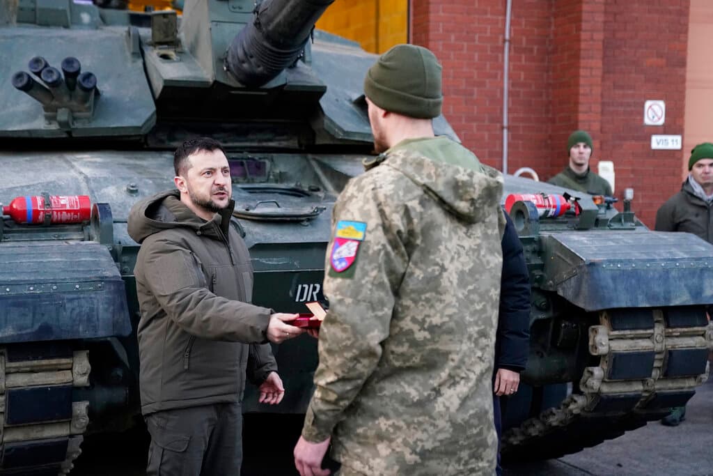 El presidente ucraniano Volodymyr Zelenskyy entrega una medalla mientras se reúne con tropas ucranianas que están siendo entrenadas para comandar tanques Challenger 2 en unas instalaciones militares en Dorset, Inglaterra, el miércoles 8 de febrero de 2023.