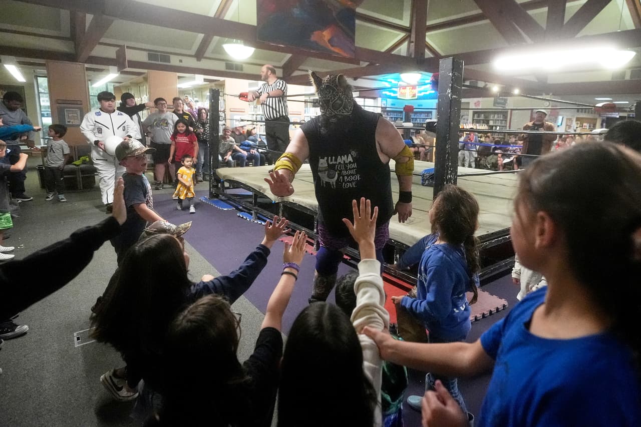 El luchador Llama Jack saluda a los aficionados durante un evento de lucha libre profesional de Lucha Libro en la Biblioteca Pública de Benicia el sábado 2 de mayo de 2026, en Benicia, California. (Foto AP/Jeff Chiu)
<br>