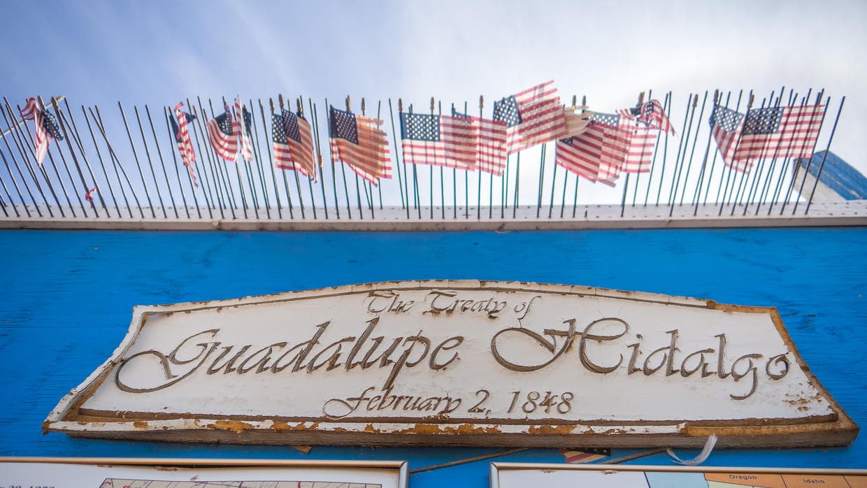 Spencer displays the 1848 U.S.-Mexico peace treaty near the border fence.