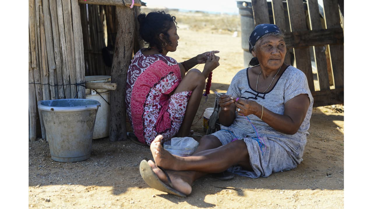 Wayuú women knit bags to sell to tourists in Cabo de la Vela. Traditionally the Wayuú do not sell their crafts, but unable to grow food many communities have turned to tourism for money.