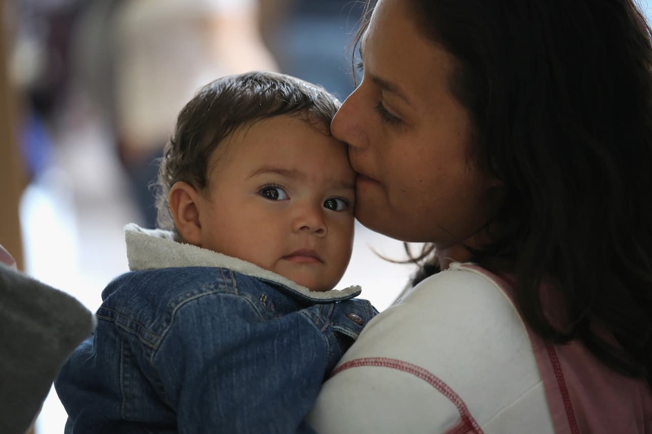 A Honduran mother and son wait to take a bus from McAllen, Texas to Florida. Immigrant rights advocates have been critical of the Obama administration's deportation tactics that target Central American refugees.