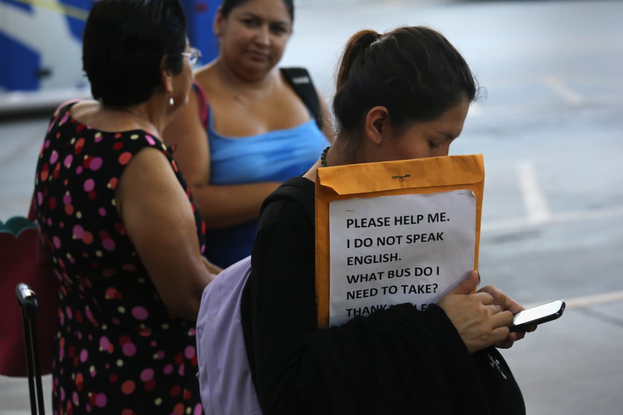 Inmigrantes A pregnant undocumented immigrant from Central America prepares for her trip, carrying a sign explaining that she doesn't speak English.