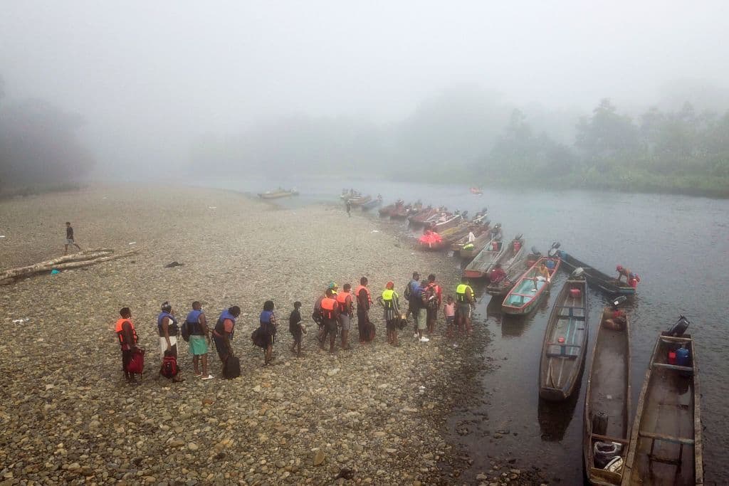 Mostyl Haitian migrants queue to be transported from Bajo Chiquito village to the Migrants Reception Station in Lajas Blancas, Darien Province, in Panama on August 23, 2021.