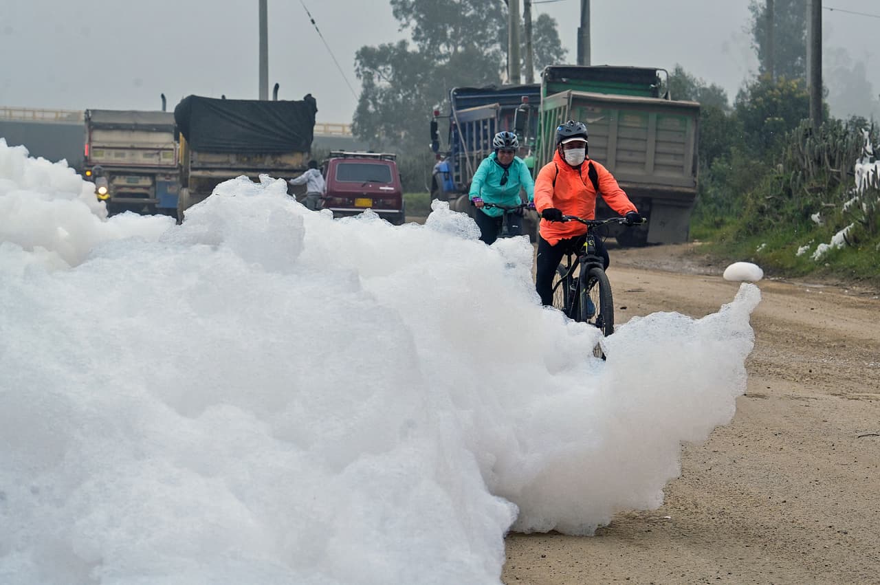 A distancia parece un espuma blanca inofensiva, pero en realidad
<b> se trata de una acumulación masiva de contaminantes con forma de algodón </b>que desbordó un río e 'invadió' una
<a href="https://www.univision.com/temas/colombia">localidad próxima a Bogotá, en Colombia.</a>
<br>
<br>En la foto, ciclistas pasean por la espuma maloliente en el barrio Los Puentes, en Mosquera, oeste de Bogotá.