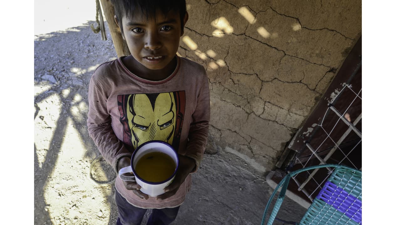 Carlos Jusayu, 11, holds a cup of dirty water from the well nearest to his home. A three-year drought in Colombia's La Guajira peninsula has limited the Jusayu family's access to clean water.