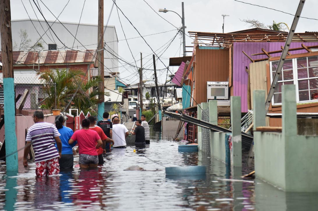 Residents wade through the streets of Catano near San Juan Bay.