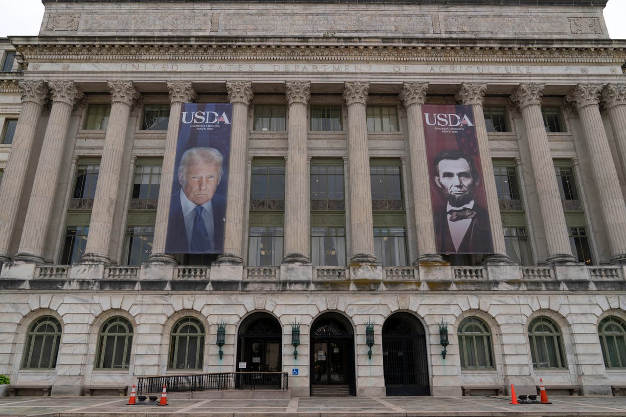 Pancartas con las fotografías del presidente Donald Trump y del presidente Abraham Lincoln cuelgan cerca de la entrada del edificio del Departamento de Agricultura de los Estados Unidos en Washington, el viernes 16 de mayo de 2025.