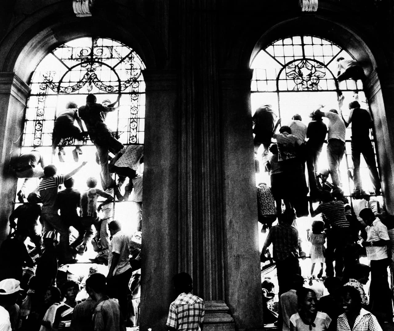 Nicaraguans climb the windows of the cathedral of Managua, next to the National Palace, try to catch sight of the arrival of the National Reconstruction Junta on July 20, 1979 a day after the triumph of the revolution. More than 100,000 people celebrated the victory of the Sandinista revolution in the streets.