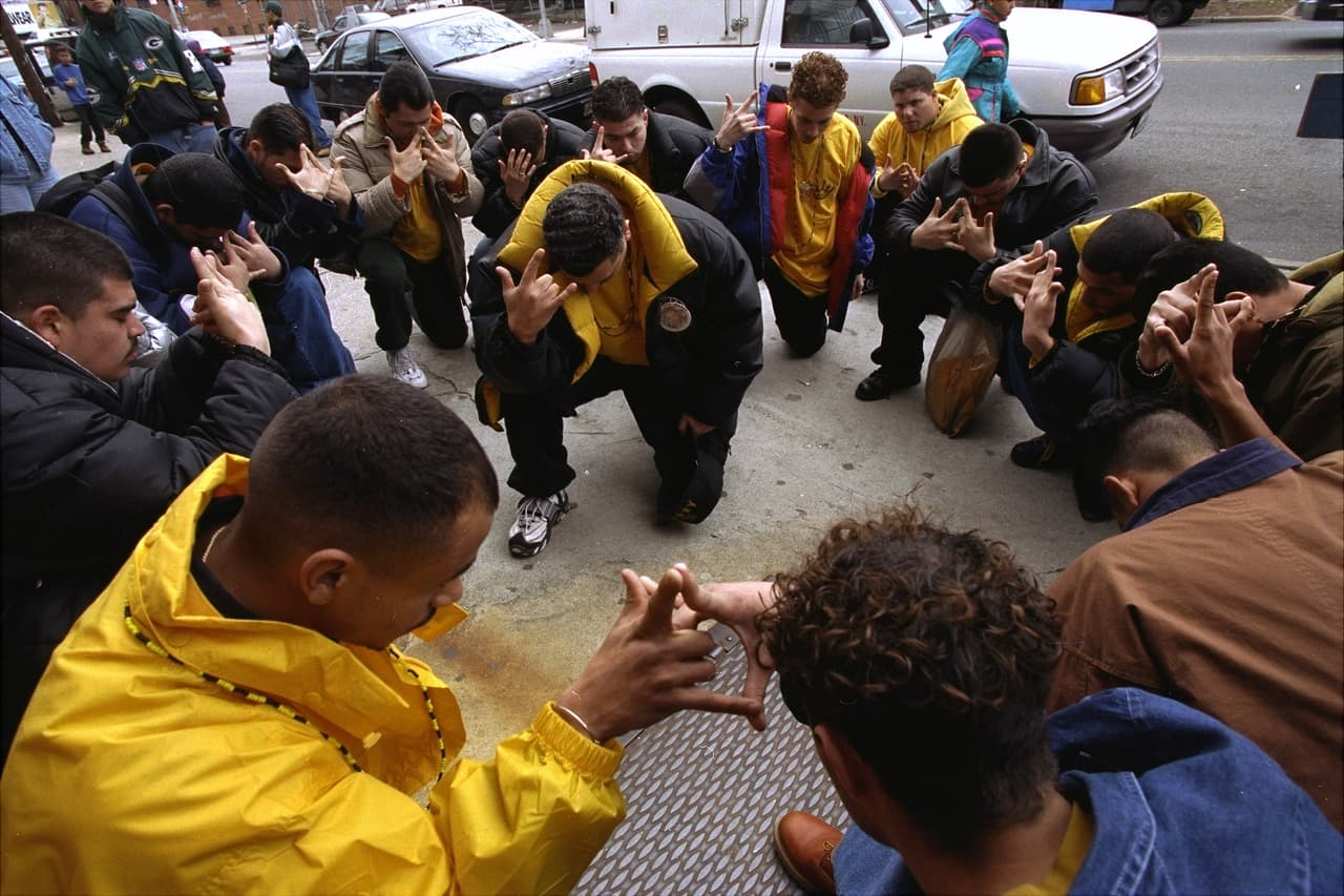 <b>Latin Kings.</b> Nació en Chicago a mediados de los 60, fue formada por inmigrantes puertorriqueños. Su estructura de liderazgo abarca el ámbito nacional, regional y local. Se rigen por una constitución y actualmente tienen participantes de varias nacionalidades y mujeres. Miembros del grupo han cometido delitos en 34 estados, principalmente en Illinois, Nueva York, Texas y Florida. También están presentes en Canadá, Cuba, República Dominicana, Ecuador, Italia, Perú y España. Se identifican con el color negro, dorado, rojo y verde. En la fotografía, miembros de Latin Kings rezan antes de una manifestación por las víctimas de un enfrentamiento con la policía de Nueva York, en 1997.