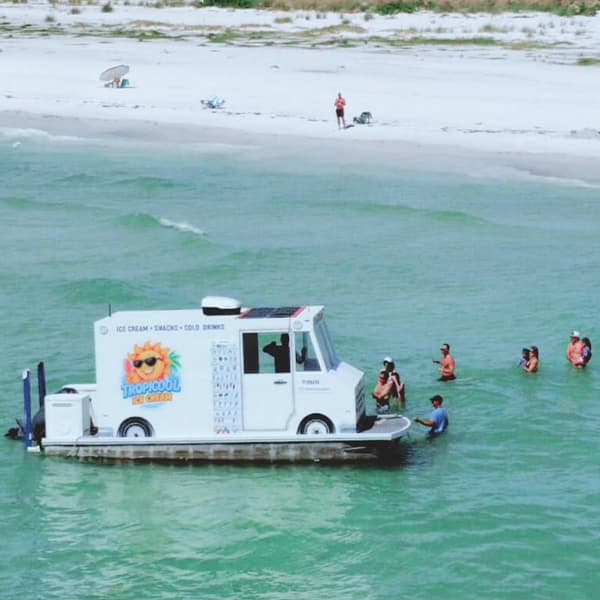 Desde el aire se aprecia mejor el concepto que ha captado la atención en redes sociales: una embarcación con la apariencia de un camión de helados recorriendo playas y bancos de arena de Florida.