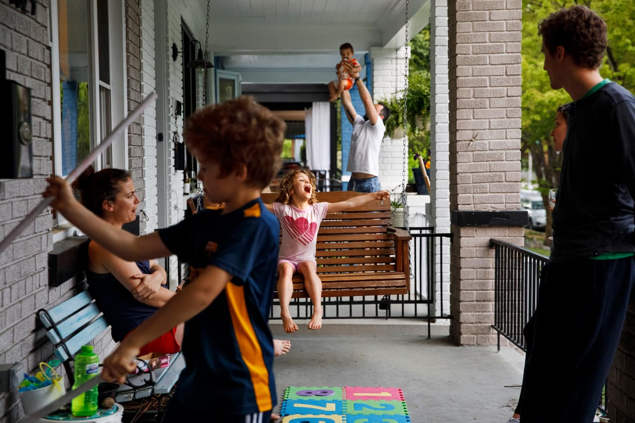 <b>Pasar el tiempo donde se pueda. </b>Un grupo de niños juega en el frente de sus casas mientras los adultos vecinos pasan el tiempo en una zona residencial de Washington DC. "No hay duda de que ha sido un bloqueo que va creciendo”, dijo Conor Williams, el padre de los niños. “La gente está en los porches de sus casas entrando y saliendo todo el día", agregó. 5 de abril.