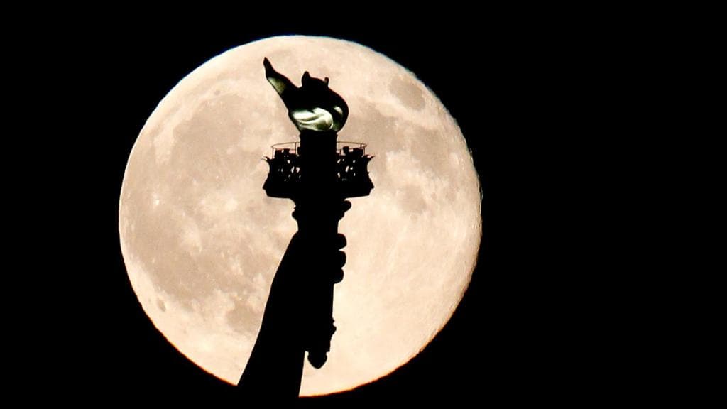 The torch of the Statue of Liberty stands out over a full moon. A poem at its base highlights how the country has opened its doors for immigrants, regardless of economic status. But conservatives take issue with that, saying the statue is strictly a beacon of freedom from oppression.